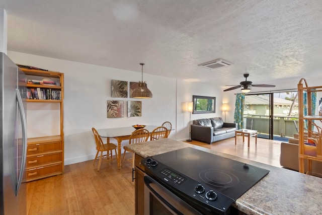 kitchen featuring ceiling fan, stainless steel fridge, light wood-type flooring, black range with electric cooktop, and decorative light fixtures