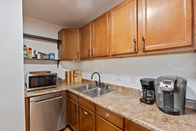 kitchen with light stone countertops, appliances with stainless steel finishes, and sink