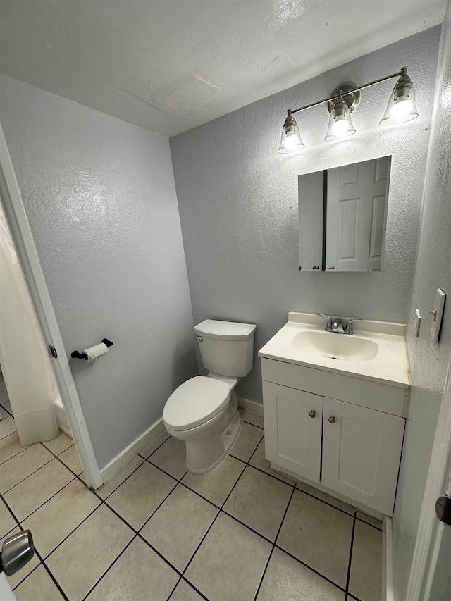 bathroom featuring toilet, vanity, and tile patterned flooring