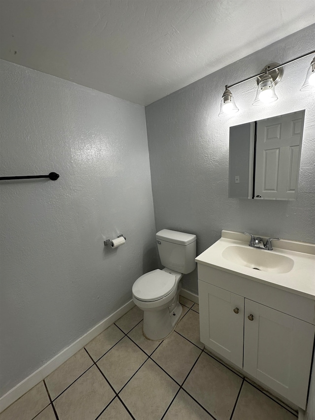 bathroom featuring vanity, toilet, and tile patterned flooring