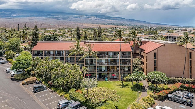 view of building exterior with a mountain view and uncovered parking
