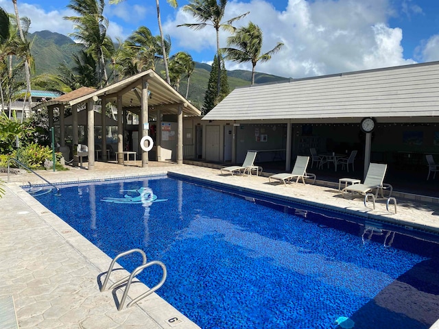 view of swimming pool featuring a mountain view and a patio