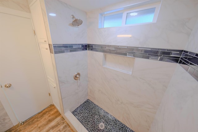 bathroom featuring a tile shower and wood finished floors