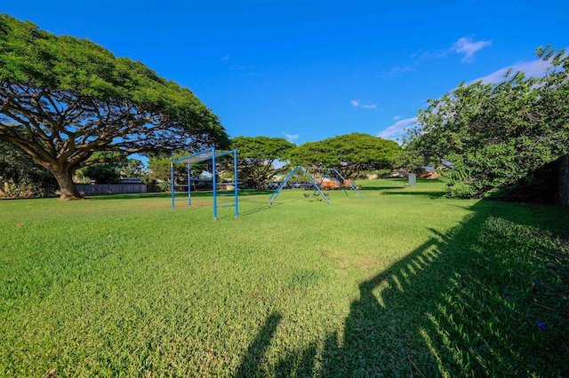 view of yard featuring playground community and fence