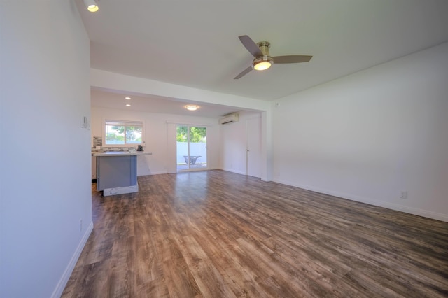 unfurnished living room with ceiling fan, dark wood-style flooring, a wall mounted air conditioner, and baseboards