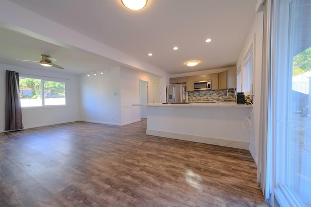 kitchen featuring appliances with stainless steel finishes, open floor plan, decorative backsplash, and dark wood-style floors