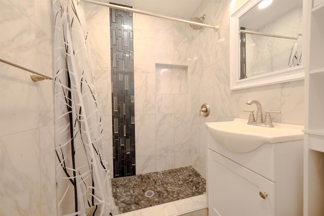 bathroom featuring tasteful backsplash, tiled shower, and vanity