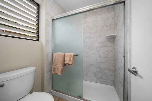 bathroom featuring walk in shower and toilet