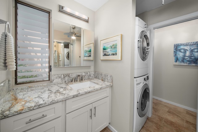 laundry room featuring stacked washer / drying machine and sink