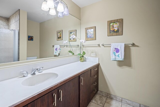 bathroom featuring a shower, toilet, vanity, and tile patterned flooring