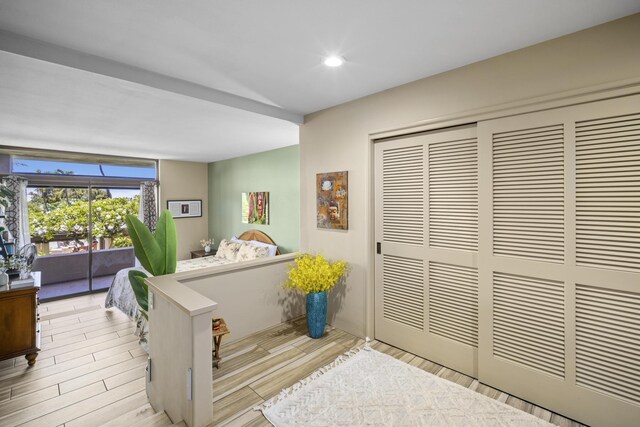 bedroom with access to exterior, a closet, and light hardwood / wood-style flooring