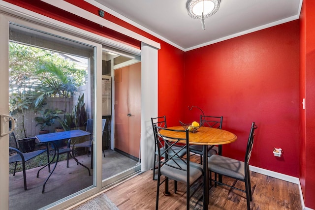 dining area with hardwood / wood-style flooring and ornamental molding