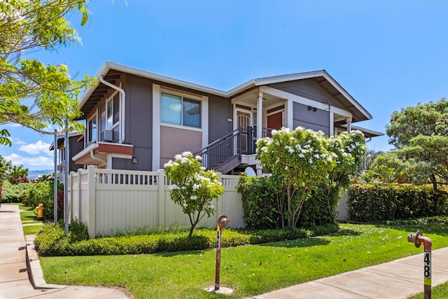 view of front of home with a balcony and a front yard