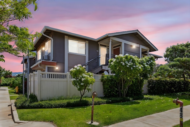 view of front of home featuring a lawn and a balcony