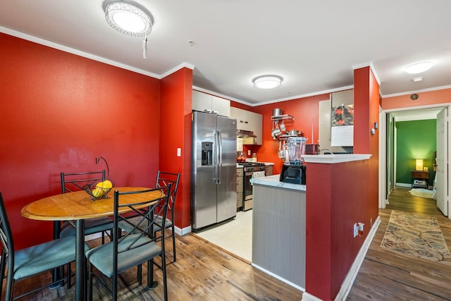 kitchen with kitchen peninsula, stainless steel appliances, crown molding, and light hardwood / wood-style flooring