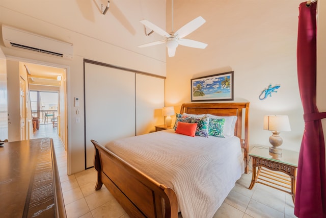 bedroom with light tile patterned floors, a wall mounted air conditioner, a closet, and ceiling fan