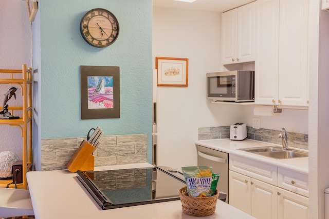 kitchen with appliances with stainless steel finishes, sink, and white cabinets