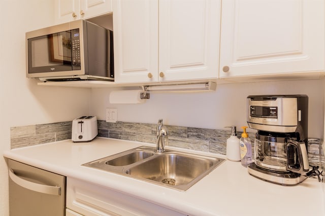 kitchen with sink, white cabinetry, and dishwashing machine