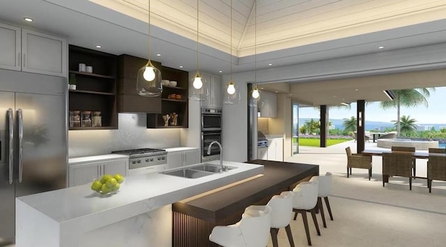 kitchen with a kitchen island with sink, stainless steel appliances, hanging light fixtures, and sink