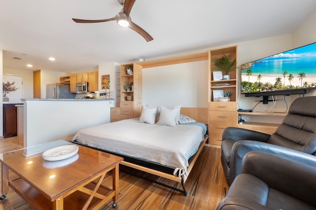 bedroom featuring stainless steel fridge, ceiling fan, and light hardwood / wood-style floors