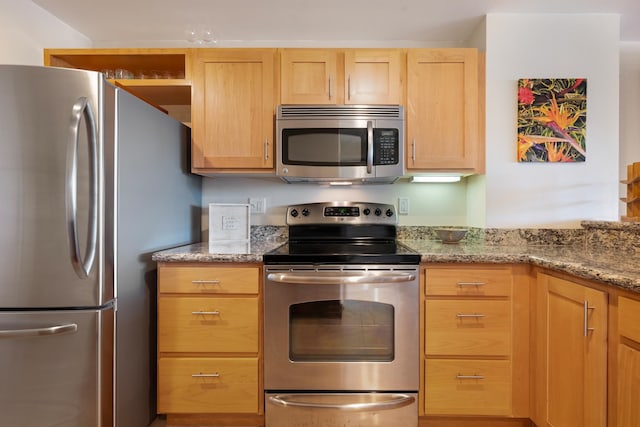 kitchen with light brown cabinets, light stone counters, and appliances with stainless steel finishes