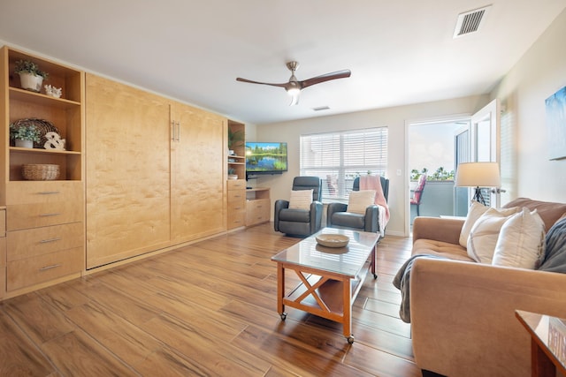 living room featuring light hardwood / wood-style flooring and ceiling fan