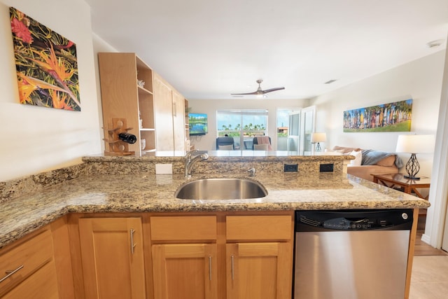 kitchen featuring light stone countertops, stainless steel dishwasher, ceiling fan, sink, and light tile patterned flooring