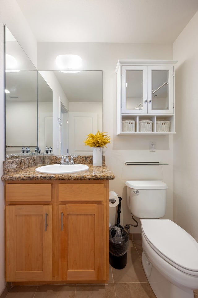 bathroom featuring tile patterned flooring, vanity, and toilet