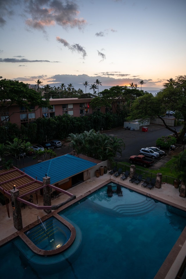 pool at dusk featuring a patio