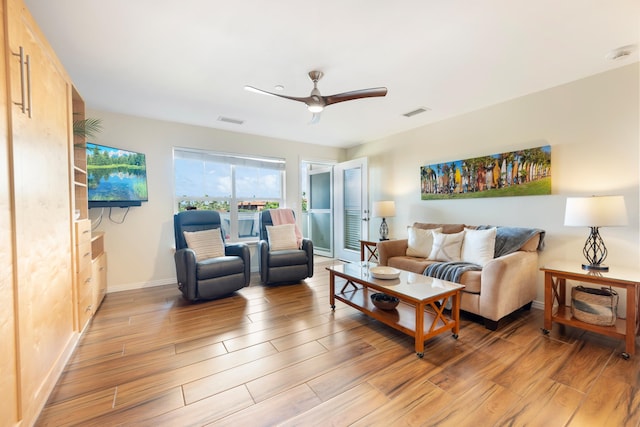 living room featuring ceiling fan and light hardwood / wood-style floors