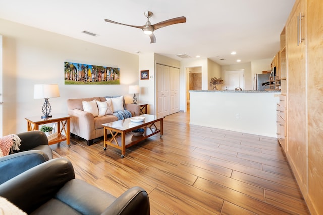 living room with ceiling fan and light hardwood / wood-style floors