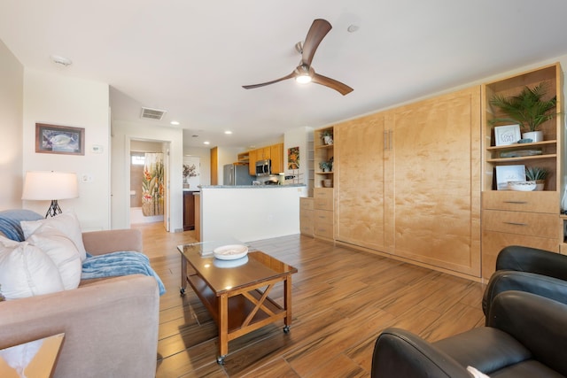 living room featuring ceiling fan and light hardwood / wood-style floors