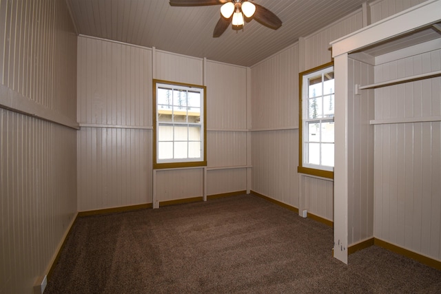 unfurnished room featuring dark carpet and ceiling fan