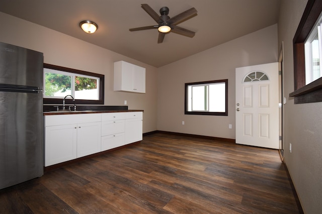 kitchen with sink, vaulted ceiling, stainless steel fridge, dark hardwood / wood-style flooring, and white cabinets