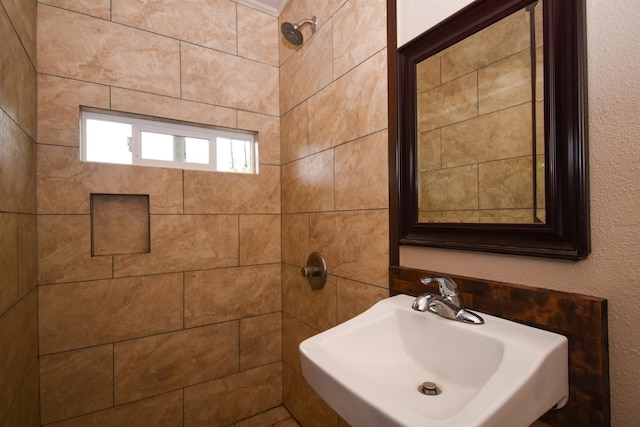 bathroom with a tile shower and sink