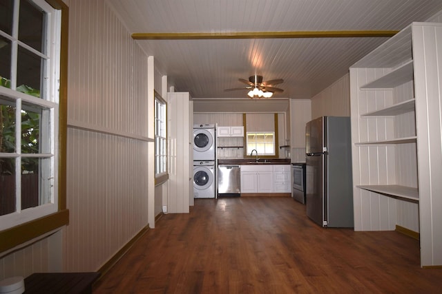 kitchen featuring dark hardwood / wood-style floors, sink, stacked washer / drying machine, ceiling fan, and stainless steel appliances