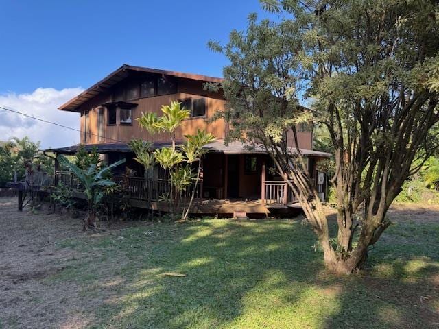 rear view of house featuring a yard