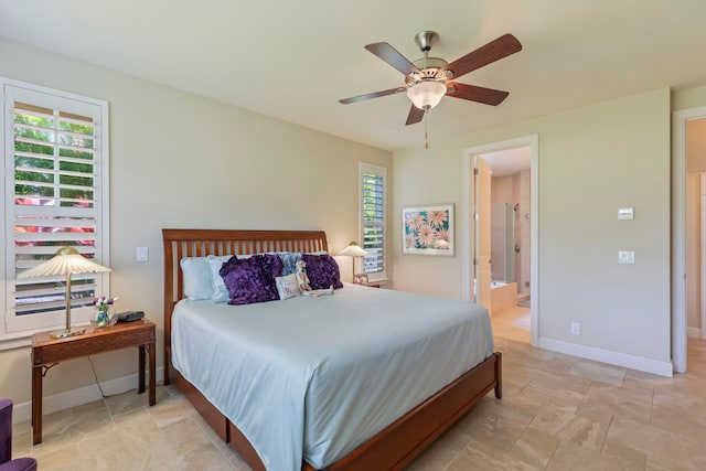 bedroom with ceiling fan, multiple windows, and ensuite bath