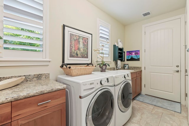 clothes washing area featuring washer and dryer, sink, and cabinets