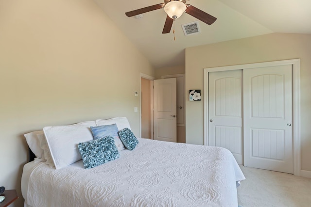 bedroom with ceiling fan, light colored carpet, a closet, and vaulted ceiling