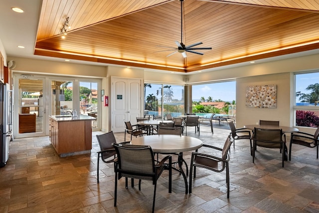 dining area featuring a raised ceiling and wood ceiling