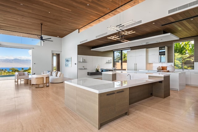 14 Halapa Pl, Kihei, HI 96753 - kitchen with modern cabinets, wooden ceiling, a large island, light wood-type flooring, and a towering ceiling