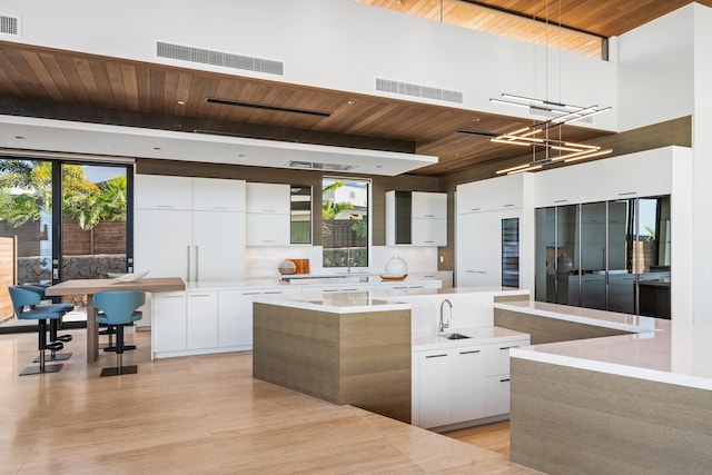 14 Halapa Pl, Kihei, HI 96753 - kitchen featuring modern cabinets, a wood ceiling with exposed beams, a kitchen island, white cabinetry, and a towering ceiling