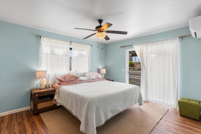 bedroom with a wall unit AC, ceiling fan, and hardwood / wood-style floors