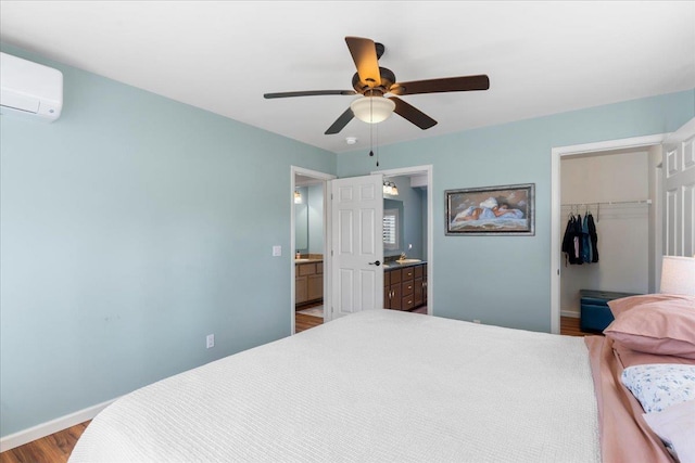 bedroom featuring ceiling fan, a spacious closet, a wall unit AC, light hardwood / wood-style floors, and a closet