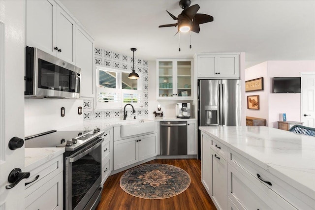 kitchen featuring appliances with stainless steel finishes, white cabinetry, dark wood-type flooring, and sink