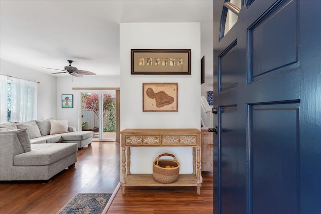 living room featuring ceiling fan and dark wood-type flooring