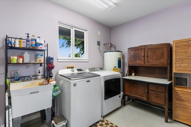 laundry area with cabinets, electric water heater, sink, and washing machine and clothes dryer