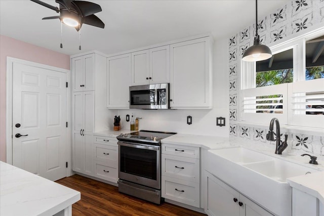 kitchen with hanging light fixtures, white cabinets, and stainless steel appliances