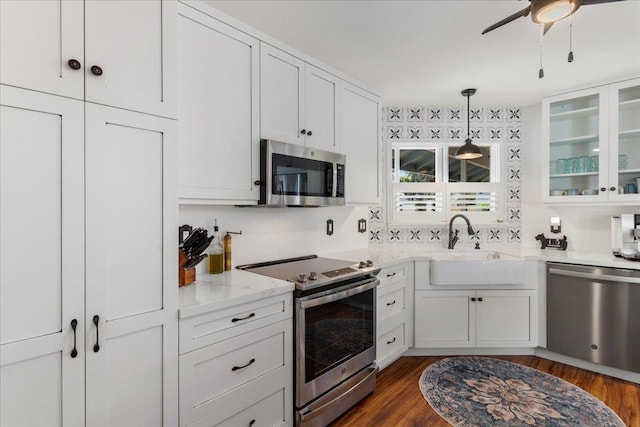 kitchen featuring sink, decorative light fixtures, dark hardwood / wood-style flooring, white cabinetry, and stainless steel appliances